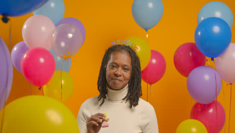 Studioporträt-Einer-Frau-Mit-Geburtstagsstirnband,-Die-Mit-Luftballons-Und-Partygebläse-Feiert-1